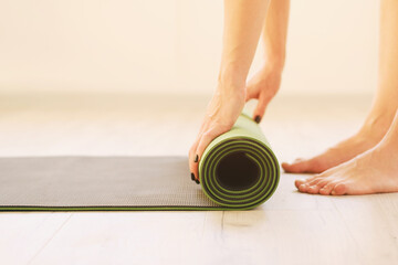 Healthy lifestyle - Girl uses yoga mat - Roll of sports mat close-up side view - Fitness and...