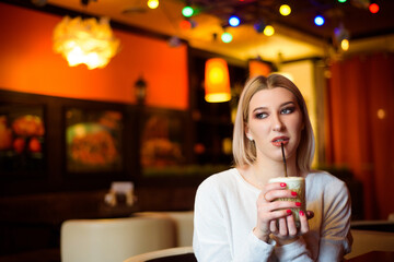 Winter girl is drinking coffee. She enjoys her cappuccino or flat white.