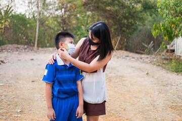 The mother is wearing a mask to protect her son from the covid-19 virus.