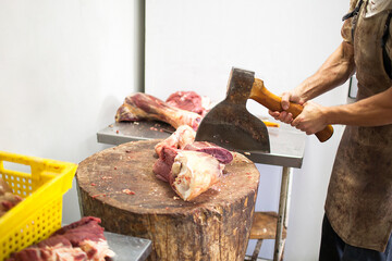 Butcher chopping meat with an axe