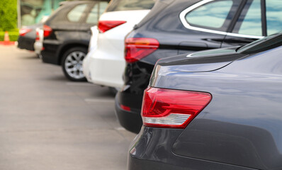 Closeup of rear side of grey car and other cars  parking in parking area.