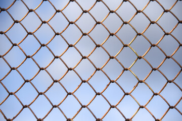 Fototapeta premium Fence with metal mesh on a background of blue sky