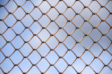 Fence with metal mesh on a background of blue sky
