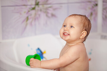 Happy baby swims in the bathtub