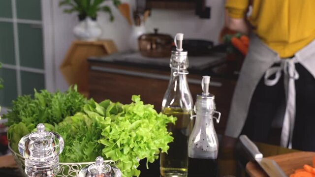 Healthy young woman in a kitchen preparing vegetables for healthy meal and salad