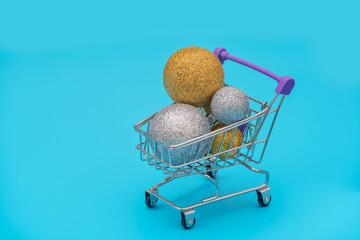 Christmas balls in the trolley on blue background