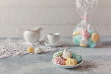 Meringues of a delicate pastel color are on the table for morning tea