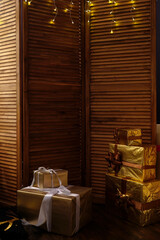 Christmas gifts in a large number of beautifully folded boxes Packed in Golden paper, decorated with bows of gold and chocolate ribbon. new year cozy background. lot of free space for text