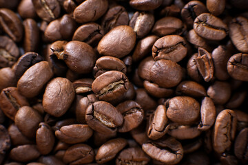 Coffee beans close up against the background of a coffee beans. Morning espresso. Coffee mug.