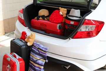 Fototapeta premium Closeup of rear side of white car carrying suitcases and things.