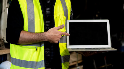 A factory engineer points to a black screen laptop