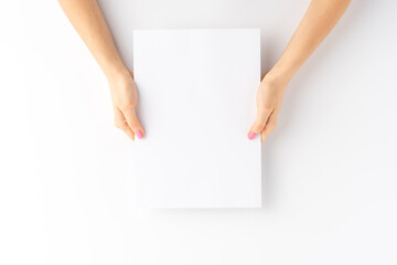 Woman’s hands holding empty white paper sheet. Close up