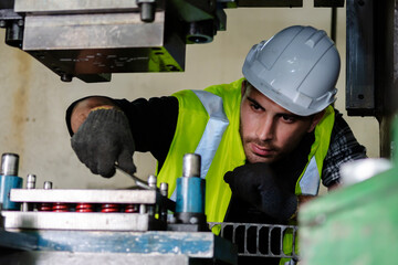 A male engineer checks the machine in the factory.