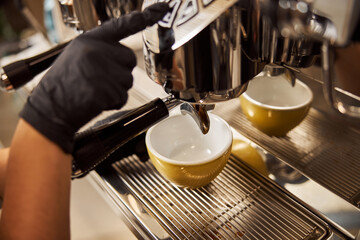Lovely yellow cup on the drip tray in cafe