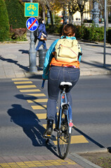 Woman is cycling at the road crossing