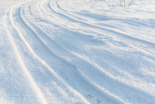 Car tire tracks on snow landscape