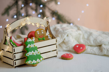 Gingerbread tree near the box on the background of a Christmas tree branch.