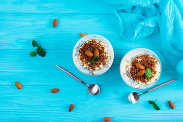 Sweet milk pudding with almonds and chocolate chips on blue background