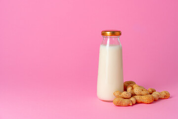 Non-dairy vegan milk made of nuts in glassware against pink background