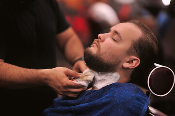 Brutal barber shaves a man in a barbershop