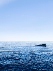 stone in the sea, peaceful blue seascape background