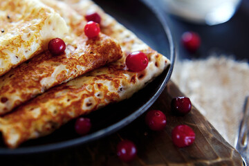 National Russian food. Pancakes in a frying pan with milk. Rustic stylization