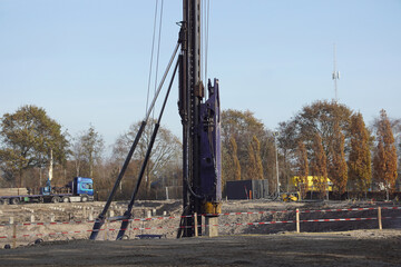 A pile driver drives a concrete pile into the ground at a Dutch construction site. Netherlands,...