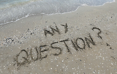 ANY QUESTION  text written on the sand of the beach