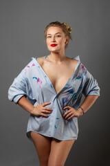 sexy girl in a shirt stained with paint with a bare shoulder.