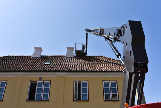 boom and basket of telescopic aerial platform of service company by repair of house