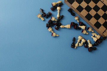 Fototapeta na wymiar Chess pieces and board on a blue background