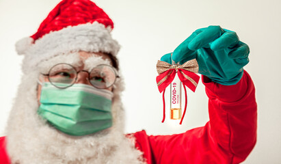 Vaccine for Christmas Gift . Santa Claus holding New Vaccine with test ampoule Positive Coronavirus infection COVID-19 . Santa Claus Wearing Medical Face Mask with glove and Coronavirus Vaccine