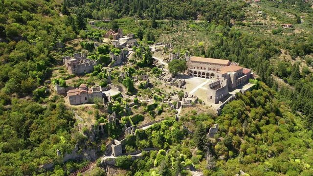 Aerial drone video of medieval byzantine old city of Mystras featuring Monastery of Pantanassa, Temple of Agia Sofia and uphill castle of Mystras, Sparta, Peloponnese, Greece