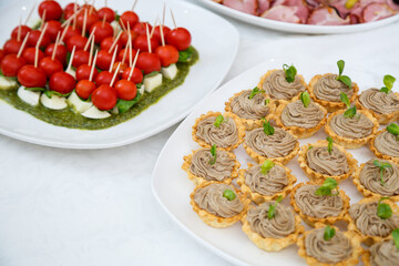 Nicely decorated banquet table with a variety of snacks and sandwich appetizers