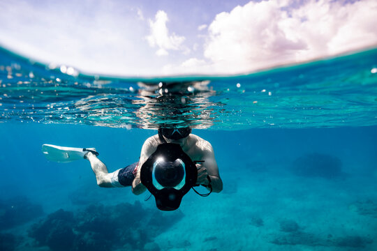 Underwater photographer in split level photo on sunny hawaii day