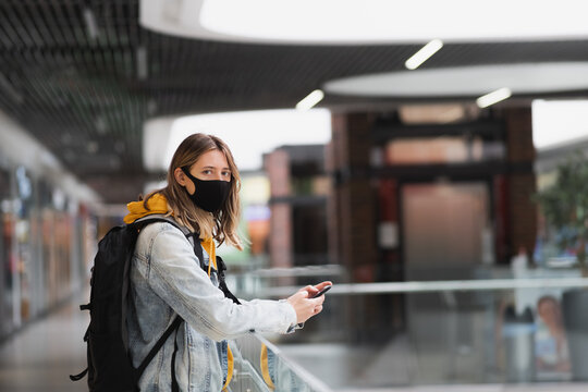 Woman in mask at a shopping centre or underground looking at cam