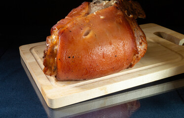 Roasted leg of the pork on wooden board