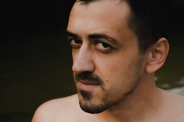 Portrait of a young male person with bristle with wet skin