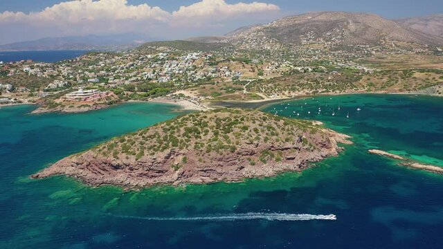 Aerial drone video of famous small islet with picturesque chapel of Agios Nikolaos and small marina, Anavissos area, Attica, Greece