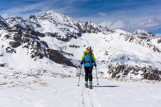 Female hiker splitboarding against snowcapped mountain