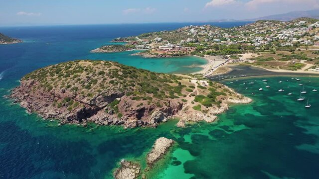 Aerial drone video of famous small islet with picturesque chapel of Agios Nikolaos and small marina, Anavissos area, Attica, Greece
