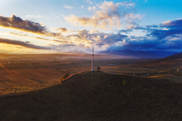 Christian cross on top of the hill with sunrays in the autumn