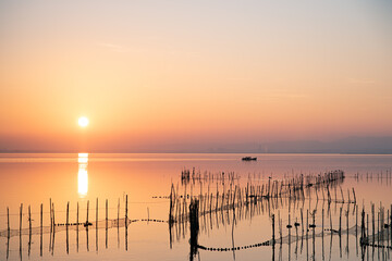 Boat and fishing nets at Valencia's Albufera sunset against the light