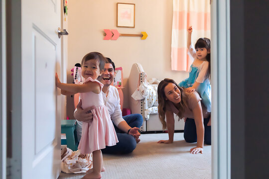 Peeking into a bedroom while family of four are playing together.