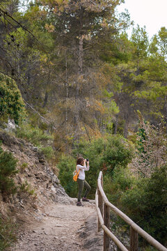 Photographer woman takes a picture with her camera in a forest