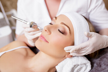 cosmetology and beauty concept - woman getting facial oxygen anti-aging procedure in beauty salon