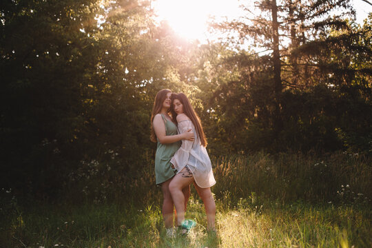 Lesbian couple romancing in forest during summer