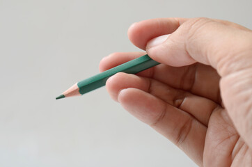 hand holding green color pencil