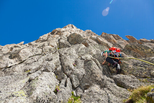 Woman rock climbs Via Amici on Lochberg, Furka Pass, Uri, Switzerland