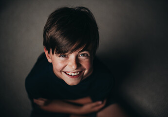 Portrait of young smiling boy with freckles shot from above.